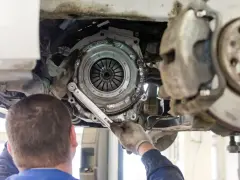Mechanik dokręca śruby koła zamachowego. Czas wymiany sprzęgła zależy od modelu auta i doświadczenia mechanika.