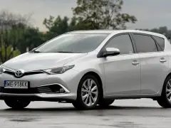 Srebrny Toyota Auris na mokrej nawierzchni. Zastanawiasz się nad pojemnością baku? Ten model oferuje komfortowe podróżowanie.